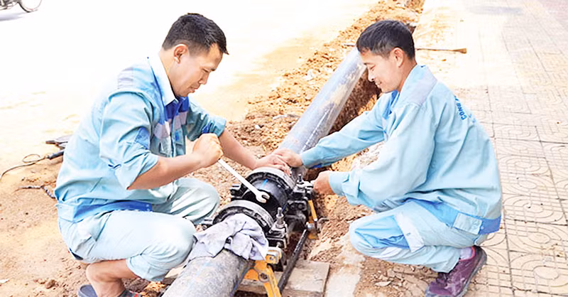 Thi công lắp đặt đường ống dẫn nước sạch tại huyện Đông Anh. (Ảnh NGUYỄN QUANG)