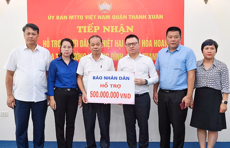 Tổng Biên tập Lê Quốc Minh cùng đoàn Báo Nhân Dân trao 500 triệu đồng hỗ trợ các nạn nhân trong vụ cháy. (Ảnh THÀNH ĐẠT)