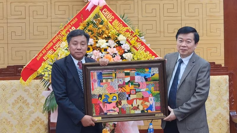 Đồng chí Nguyễn Văn Chương, Phó Chủ tịch Ủy ban nhân dân tỉnh Hòa Bình (phải) tặng Phó Tỉnh trưởng tỉnh Hủa Phăn, ông Phút Phăn Kẹo Vông Xay bức tranh mang đậm nét văn hóa dân tộc Mường.
