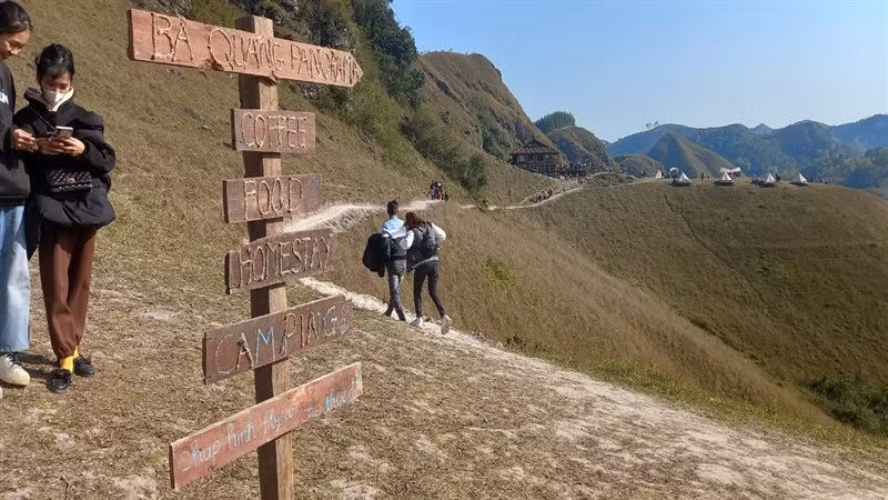 Biển chỉ dẫn vào khu camping đồi cỏ Ba Quáng, với khu nhà sàn và những lều vải xinh xắn, thơ mộng.