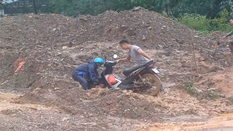 Người dân khó nhọc, nỗ lực đưa xe máy qua vị trí đường tắc.