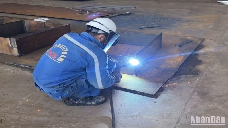 Công nhân Công ty công nghiệp tàu thủy Dung Quất hàn kim loại tại phân xưởng sửa chữa tàu.