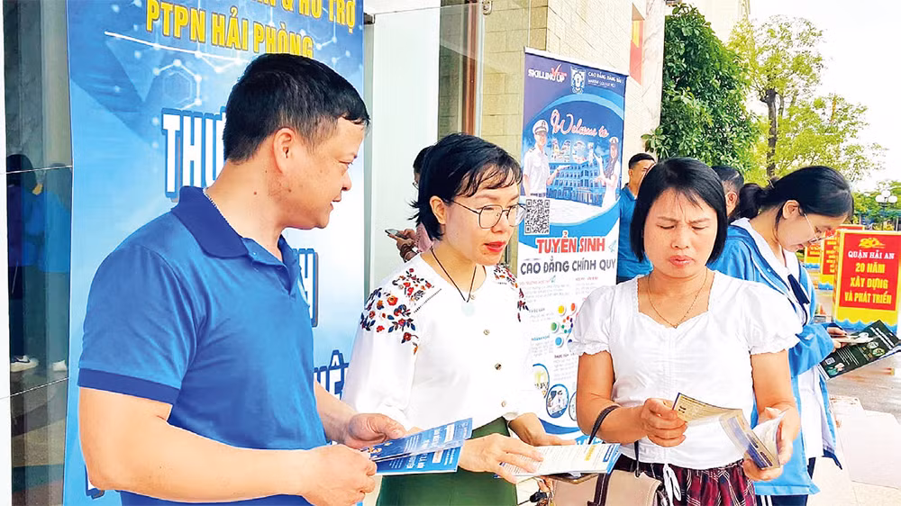 Cán bộ Bảo hiểm xã hội Hải Phòng tuyên truyền chính sách bảo hiểm xã hội tự nguyện, bảo hiểm y tế hộ gia đình tại các phiên giao dịch việc làm. (Ảnh QUANG MINH)