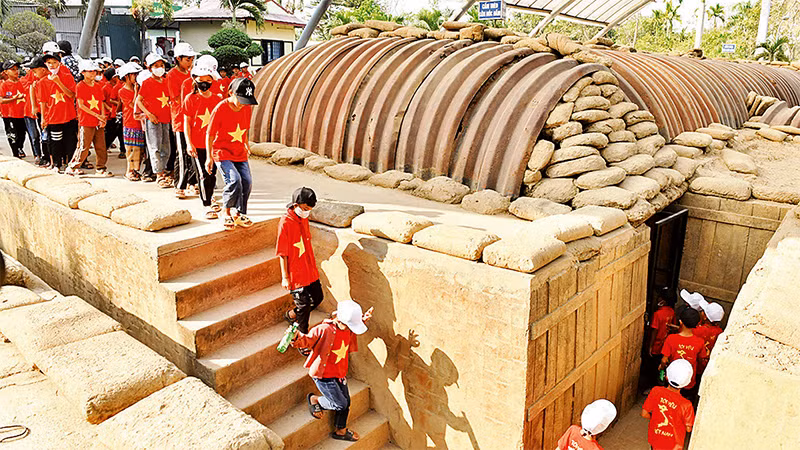 Các em học sinh tham quan, tìm hiểu lịch sử tại khu di tích hầm Đờ Cát. Ảnh: ĐĂNG KHOA