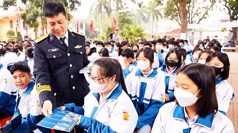Cán bộ Lữ đoàn đặc công Hải quân 126 phát tờ rơi, tuyên truyền đến học sinh Trường THPT Lạng Giang số 1. (Ảnh Quốc Phương)