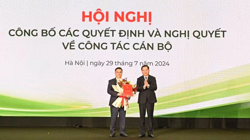 Ông Nguyễn Long Hải (bên phải) trao Quyết định và tặng hoa chúc mừng tân Bí thư Đảng ủy Vietcombank Nguyễn Thanh Tùng.