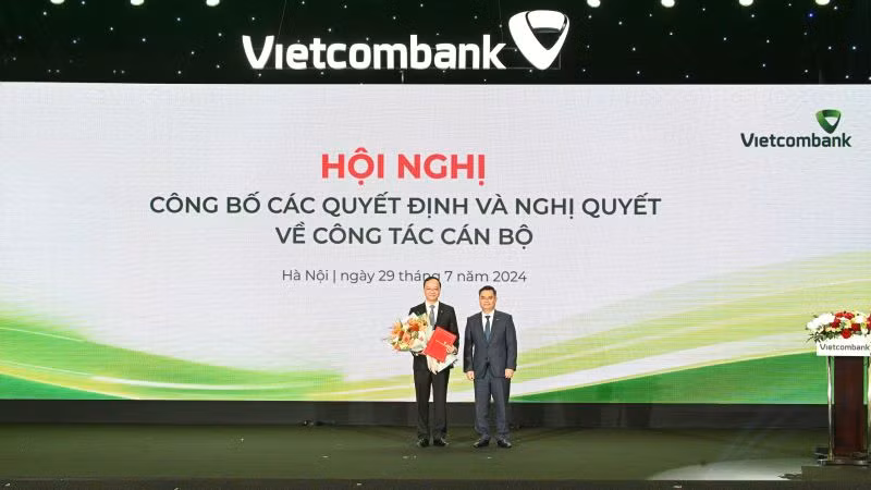Bí thư Đảng ủy, Chủ tịch Hội đồng quản trị Vietcombank Nguyễn Thanh Tùng (bên phải) trao Quyết định và tặng hoa chúc mừng ông Lê Quang Vinh.