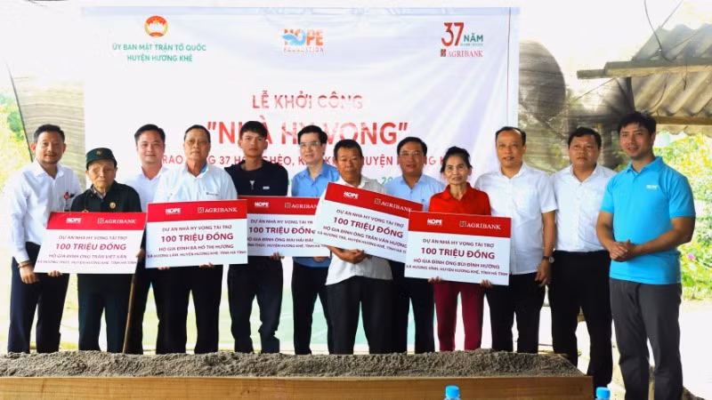 Đại diện các nhà tài trợ và lãnh đạo huyện Hương Khê trao biểu trưng hỗ trợ cho các gia đình.