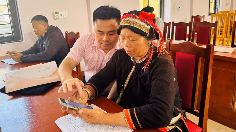 Cán bộ Ngân hàng Chính sách xã hội hướng dẫn bà con sử dụng ứng dụng moblie quản lý tín dụng chính sách.