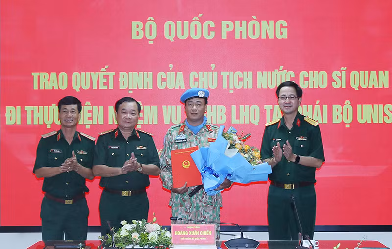 Thượng tướng Hoàng Xuân Chiến trao Quyết định của Chủ tịch nước và tặng hoa chúc mừng Trung tá Đặng Quốc Tuấn. 