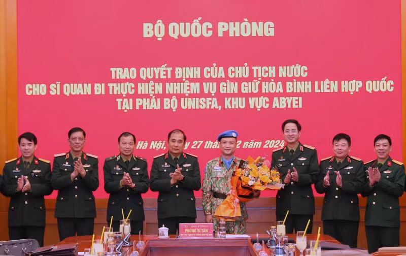 Thượng tướng Phùng Sĩ Tấn cùng đại diện các cơ quan, đơn vị chúc mừng Thiếu tá Hoàng Đình Công chuẩn bị lên đường làm nhiệm vụ giữ gìn hòa bình Liên hợp quốc. 