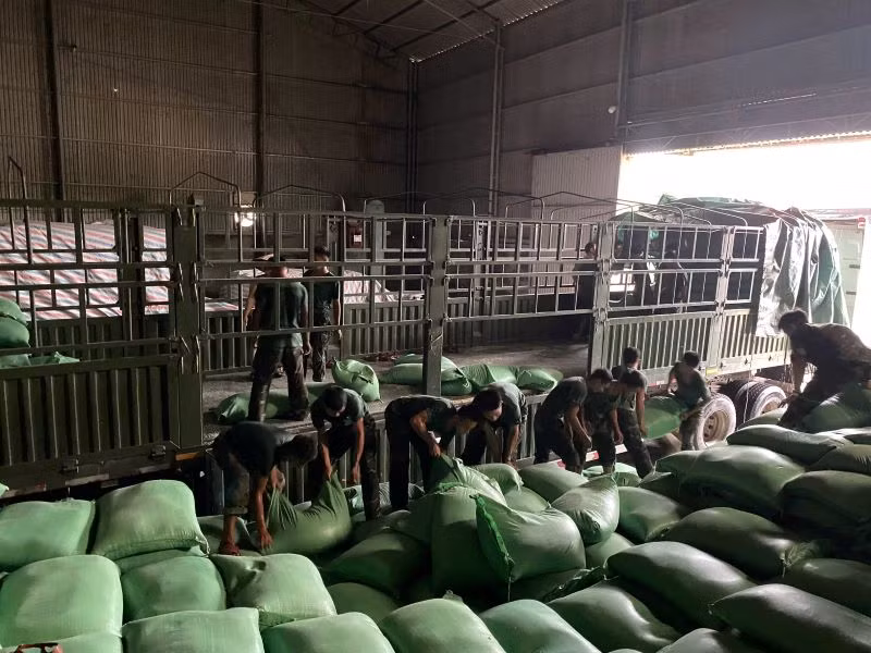 Cán bộ, chiến sĩ Trung đoàn 101, Sư đoàn 325 giúp địa phương vận chuyển 130 tấn gạo tại kho gạo xã Nghĩa Hồ, huyện Lục Ngạn, tỉnh Bắc Giang đến nơi an toàn.
