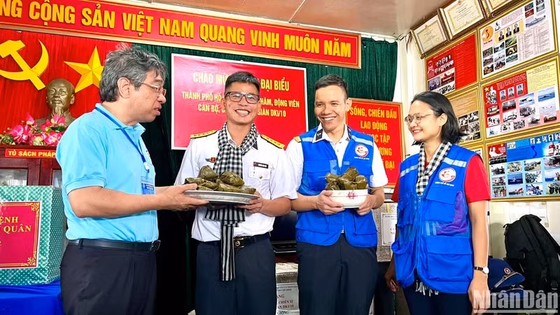 Đồng chí Nguyễn Phước Lộc, Phó Bí thư Thành ủy, Chủ tịch Ủy ban Mặt trận Tổ quốc Việt Nam Thành phố Hồ Chí Minh (bên trái) trao bánh giò mới nấu đến cán bộ, chiến sĩ trên nhà giàn DK1/10.