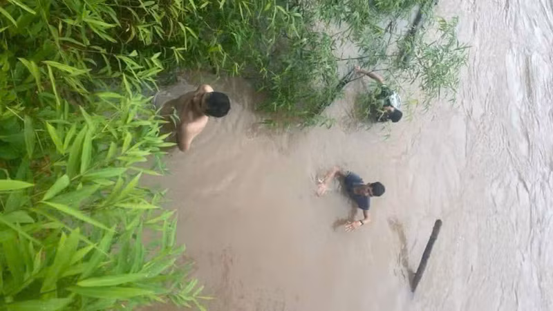 Thời điểm hai người dân đưa được lái xe vào bờ. Thời điểm hai người dân đưa được lái xe vào bờ.