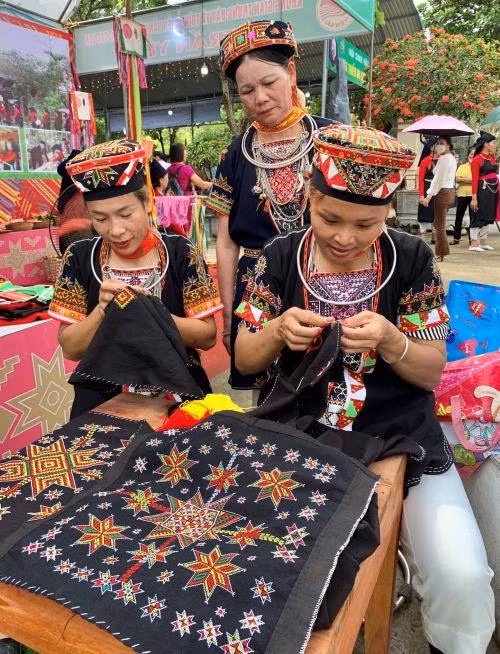 Phụ nữ người Dao quần trắng thể hiện sự khéo léo qua đường kim mũi chỉ.
