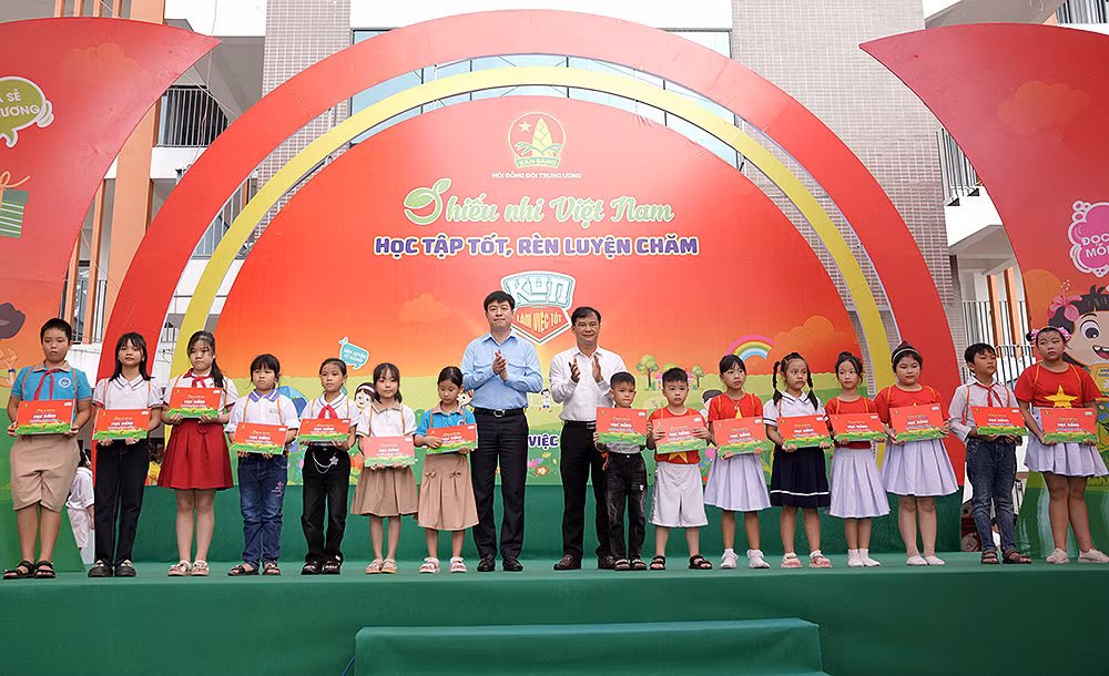 Phó Chủ tịch Thường trực Hội đồng Đội Trung ương Lê Hải Long (8 từ trái sang) cùng đại diện các đơn vị liên quan trao học bổng tặng thiếu nhi vượt khó học tốt.