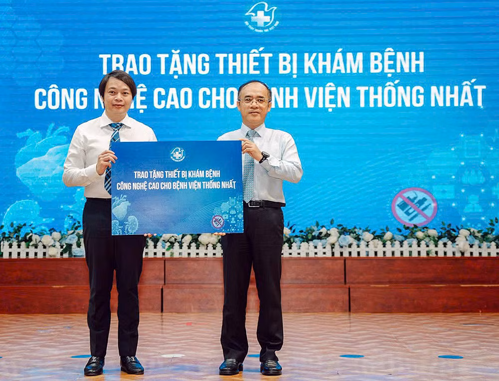 Đồng chí Nguyễn Hữu Tú (bên trái) trao tượng trưng các thiết bị y tế tặng Bệnh viện Thống Nhất.