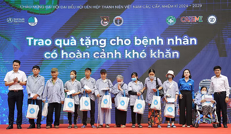 Phó Chủ tịch Hội Liên hiệp Thanh niên Việt Nam Nguyễn Kim Quy (ngoài cùng bên trái) và đại diện các đơn vị liên quan trao quà tặng người bệnh, gia đình người bệnh.