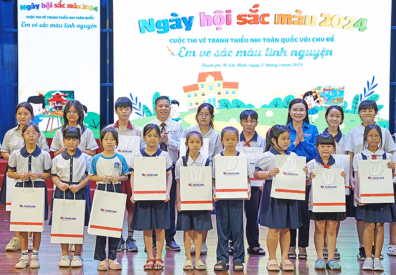 Bí thư Trung ương Đoàn, Chủ tịch Hội đồng Đội Trung ương Nguyễn Phạm Duy Trang (áo xanh) và đại diện các đơn vị liên quan trao quà tặng thiếu nhi có thành tích tốt trong học tập.