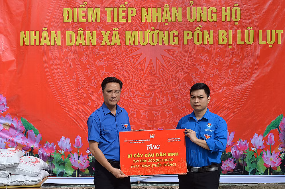 Bí thư Tỉnh đoàn Điện Biên Đặng Thành Huy (trái) trao tượng trưng kinh phí xây dựng "Cầu dân sinh" tặng người dân, thanh thiếu nhi Mường Pồn.
