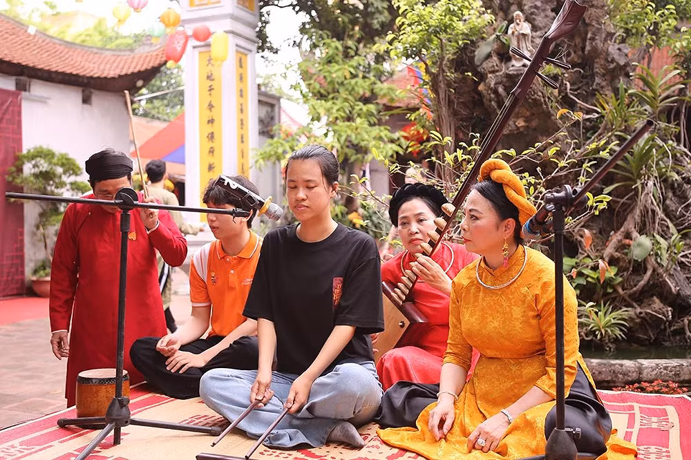 Một bạn trẻ tham gia trải nghiệm chơi nhạc cụ dân tộc trong khuôn viên Bích Câu Đạo Quán.