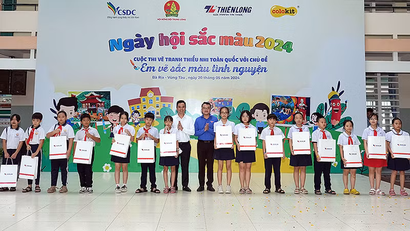 Phó Chủ tịch Hội đồng Đội Trung ương Lê Anh Quân (thứ 8 từ trái sang) cùng đại diện các đơn vị liên quan trao quà tặng học sinh vượt khó học tốt tại Ngày hội.