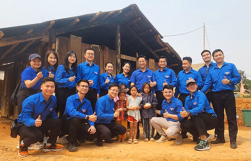 Đoàn viên, thanh niên các đơn vị cùng thiếu nhi địa phương trước thềm những ngôi nhà sẽ được xây dựng lại thành Nhà Đại đoàn kết.