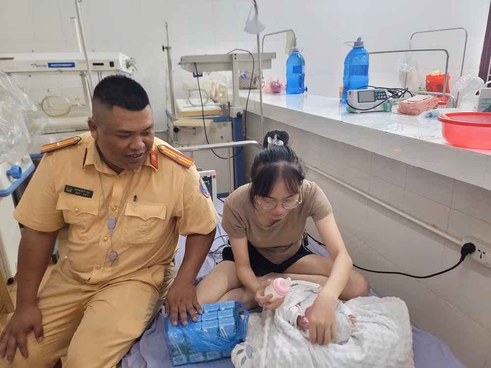 Thiếu tá Phạm Duy Anh thăm hỏi cháu bé và gia đình.