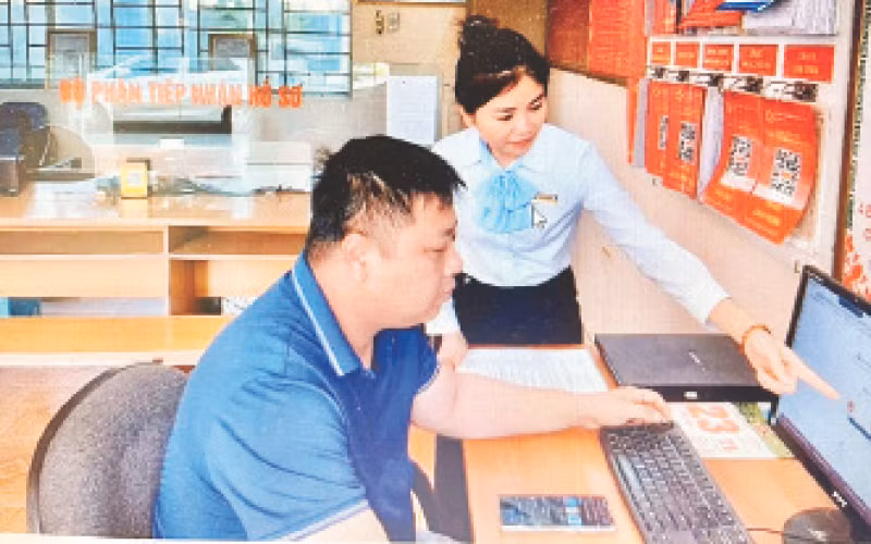 Cán bộ bộ phận “một cửa” xã Minh Khai hướng dẫn người dân thực hiện thủ tục hành chính (ảnh Công Tâm)