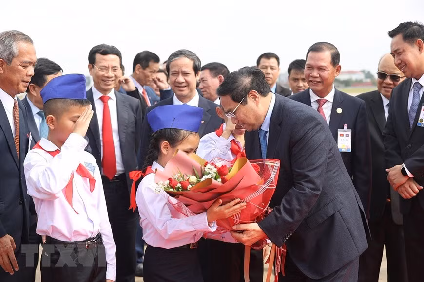 Các cháu thiếu nhi tặng hoa trong lễ tiễn Thủ tướng Phạm Minh Chính tại sân bay Quốc tế Wattay, thủ đô Vientiane. (Ảnh: Dương Giang/TTXVN)