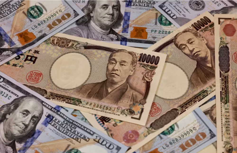 Đồng 10.000 yen và đồng 100 USD. Ảnh: AFP/TTXVN.