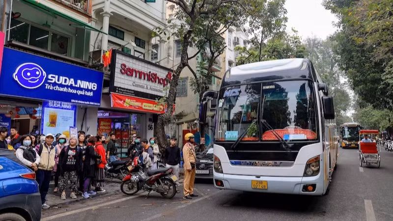 Lực lượng chức năng xử lý xe chở khách vi phạm tại khu vực phố cổ. (Ảnh: CHU DŨNG)