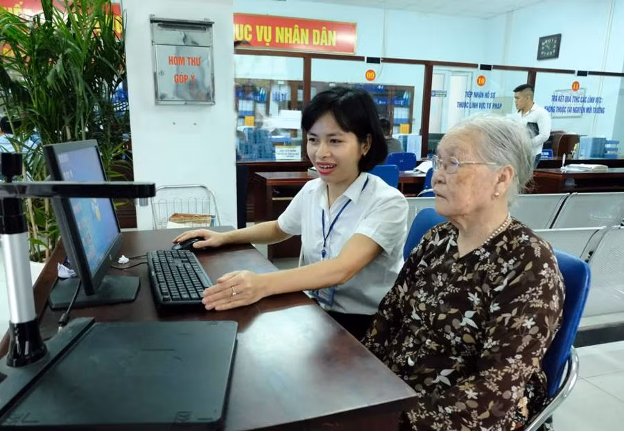 Cán bộ Ủy ban nhân dân quận Bắc Từ Liêm (Hà Nội) hướng dẫn người dân giải quyết thủ tục hành chính. (Ảnh: CÔNG HÙNG)