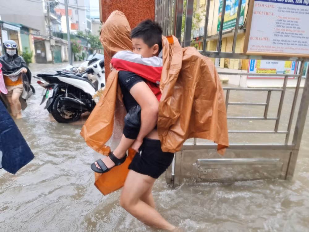 Phụ huynh đến đón con về vì phòng học bị ngập tại trường Tiểu học Phú Lương 2, quận Hà Đông. (Ảnh: CTV)