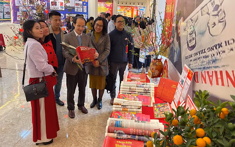 Lãnh đạo và nhiều phóng viên cơ quan báo chí quan tâm đến các ấn phẩm của Báo Nhân Dân.