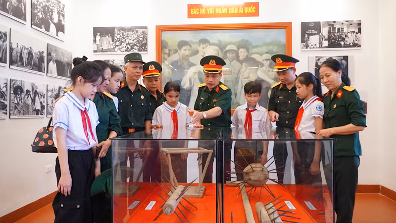 Cán bộ, chiến sĩ lực lượng vũ trang và các em học sinh thăm gian trưng bày hiện vật tại Nhà tưởng niệm Chủ tịch Hồ Chí Minh.