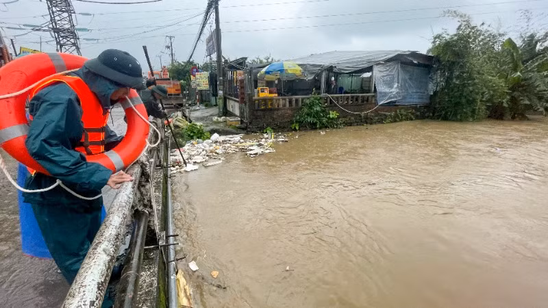 Lực lượng chức năng trục vớt rác thải trên mặt kênh thoát nước.