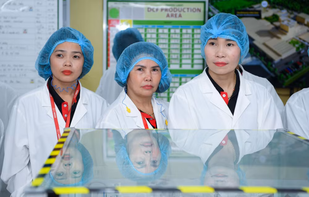 Trang (bìa trái) có cơ hội tham quan dây chuyền sản xuất cà phê tại nhà máy Nestle Trị An cùng 50 nông dân xuất sắc của Chương trình NESCAFÉ Plan