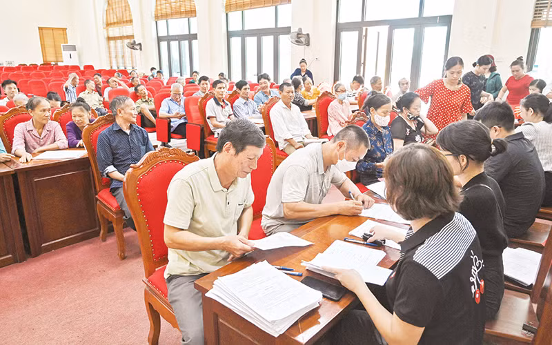 Người dân xã Đắc Sở, huyện Hoài Đức nhận tiền hỗ trợ giải phóng mặt bằng dự án đường vành đai 4-Vùng Thủ đô. (Ảnh Duy Linh)