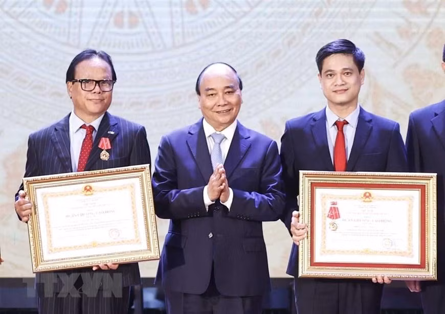 Chủ tịch nước Nguyễn Xuân Phúc trao tặng Huân chương Lao động hạng Ba cho tập thể và cá nhân Trường đại học Kinh tế quốc dân. (Ảnh: Thống Nhất/TTXVN)
