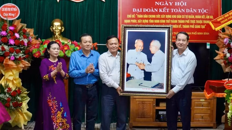Phó Bí thư Thường trực Tỉnh ủy, Chủ tịch Hội đồng nhân dân tỉnh Ninh Bình Mai Văn Tuất trao tặng bức ảnh "Bác Hồ và Bác Tôn bắt tay đoàn kết" cho đại diện khu phố 4.