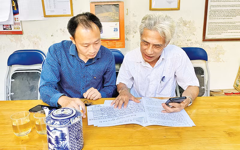 Lãnh đạo Ủy ban Mặt trận Tổ quốc phường Ngọc Khánh, quận Ba Đình (bên trái) trao đổi với ông Nguyễn Hữu Bằng, Bí thư Chi bộ, Trưởng ban Công tác Mặt trận địa bàn dân cư số 3 về công tác giám sát đảng viên sinh hoạt hai chiều.