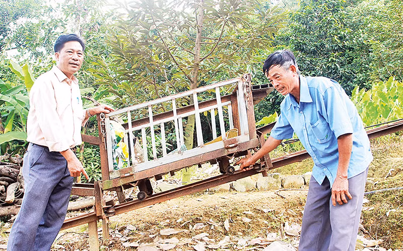Một phần hệ thống máy vận chuyển trên địa hình dốc của ông Trần Văn Túy (bên phải).