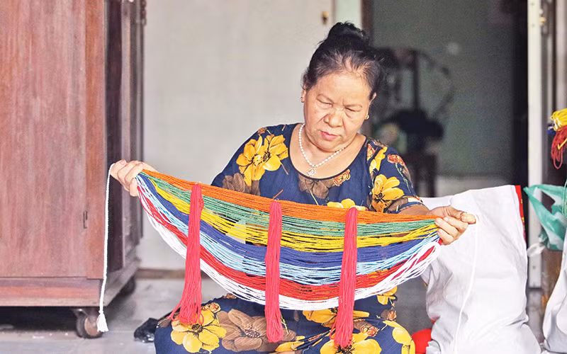Bà Hồ Thị Non giới thiệu vòng cườm đá đeo ở lưng của người Cor. 