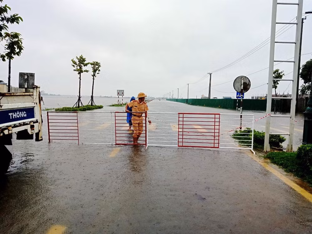 Lực lượng chức năng ngăn đường vùng ngập lụt cấm người dân qua lại. Lực lượng chức năng ngăn đường vùng ngập lụt cấm người dân qua lại.