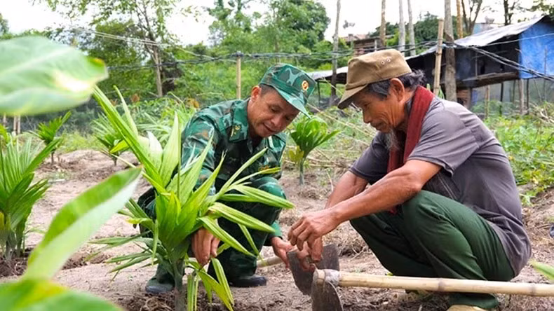 Cán bộ Đồn Biên phòng Dục Nông (Bộ Chỉ huy Bộ đội Biên phòng tỉnh Kon Tum) hướng dẫn người dân canh tác cây trồng. (Ảnh: MAI HƯƠNG)