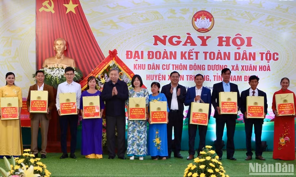 Đại tướng Tô Lâm và Bí thư Tỉnh ủy Nam Định Phạm Gia Túc tặng quà cho bà con thôn Đông Dương, xã Xuân Hòa, huyện Xuân Trường trong Ngày hội Đại đoàn kết toàn dân tộc tại địa phương.