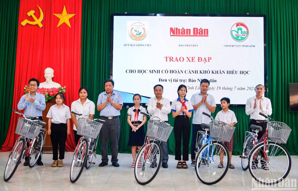 Đồng chí Đinh Như Hoan, Phó Tổng Biên tập Báo Nhân Dân trao tặng xe đạp cho học sinh có hoàn cảnh khó khăn hiếu học tại huyện Vĩnh Linh. (Ảnh: THÀNH ĐẠT)