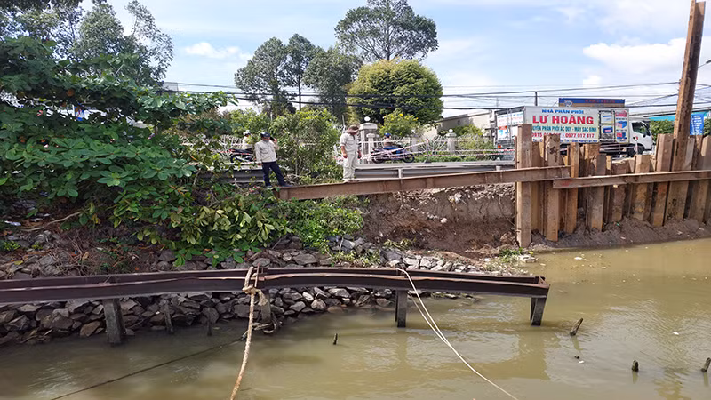 Thanh sắt chắn bị bung ra, rọ đá rơi vào lòng sông. Thanh sắt chắn bị bung ra, rọ đá rơi vào lòng sông.