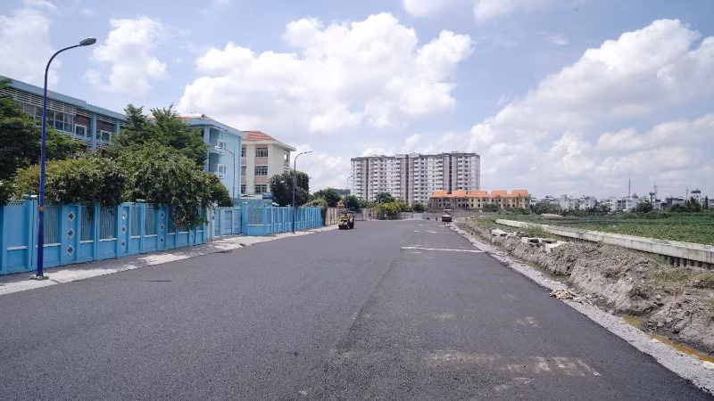 Gói thầu số 8, đoạn trước cổng trường Trung học cơ sở Huỳnh Văn Nghệ hướng ra dòng kênh Tham Lương đã hoàn tất thảm nhựa đường, sẵn sàng tổ chức thông xe (Ảnh: THẾ ANH)